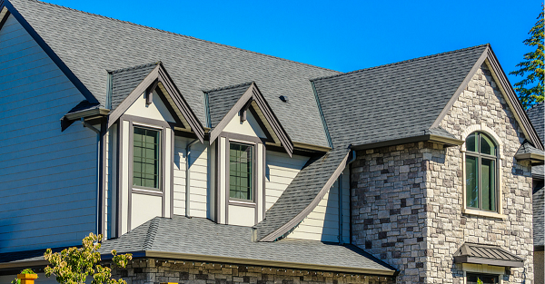 A two story brick home with a new asphalt shingle roof installed by Trico Exteriors in Charleston, SC