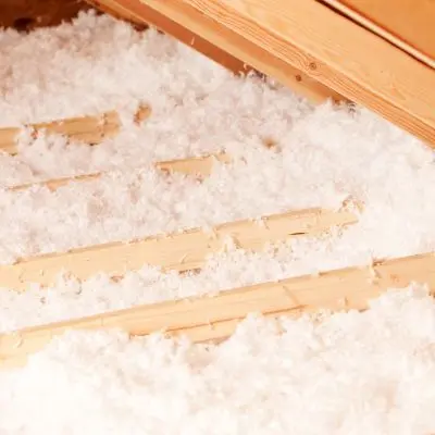 Attic insulation with visible wooden beams.